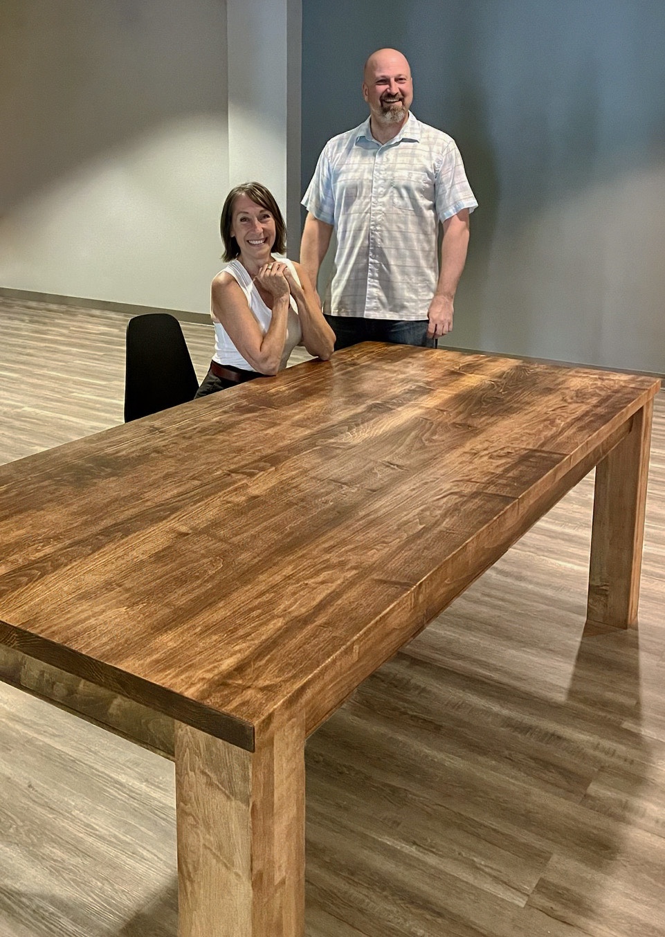 Maple table shown with two people to indicate scale.